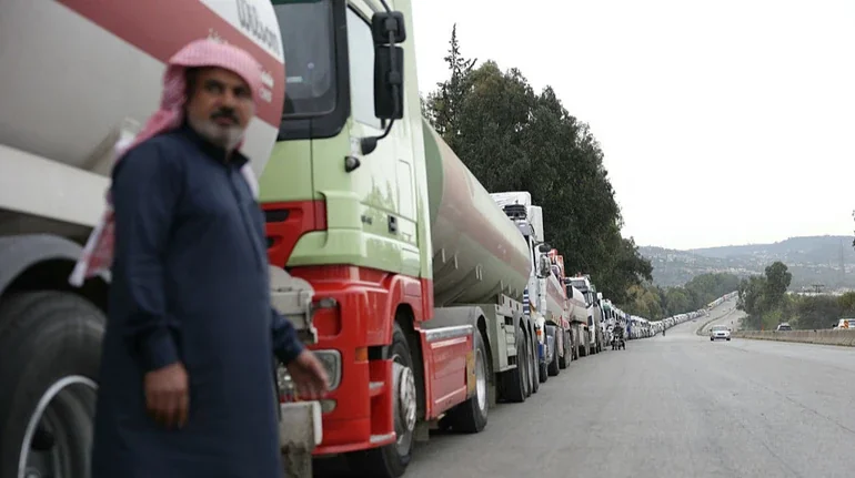 Иракский водитель в традиционной куфии возле колонны грузовиков с мазутом на пути через Сирию в обход Ормузского пролива