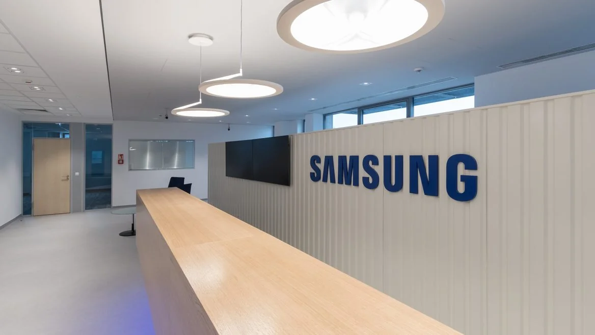 Офис Samsung с большим синим логотипом на стене и ресепшеном в современном интерьере