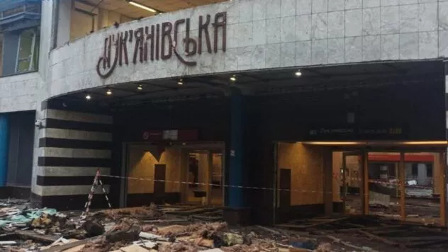 Повреждённый наземный вестибюль станции метро «Лукьяновская» в Киеве после российского обстрела с обломками и ограждением.