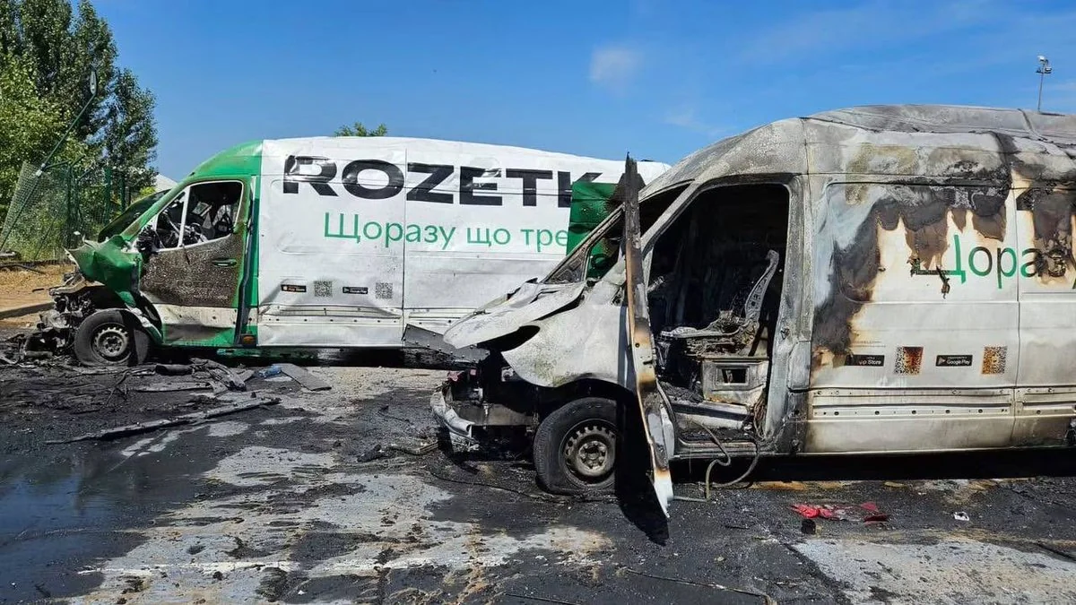 Два обгорілі фургони Rozetka на згорілому асфальті після удару