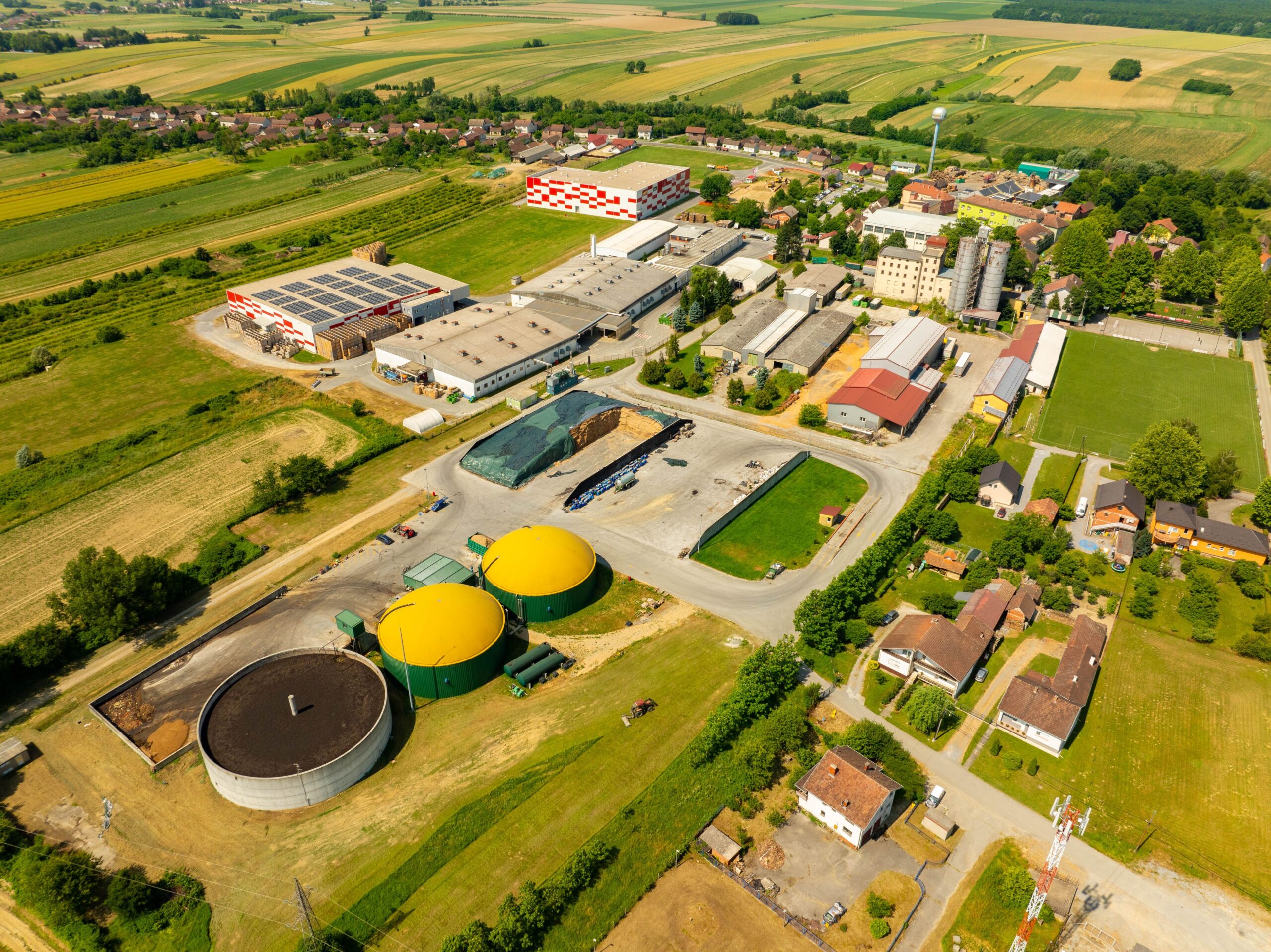 Аерозйомка біогазової станції з жовтими куполами серед полів і будівель
